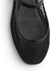 Vista de material sintético en flats negros para mujer con hebilla redonda en correa ajustable tipo balerinas perforadas
