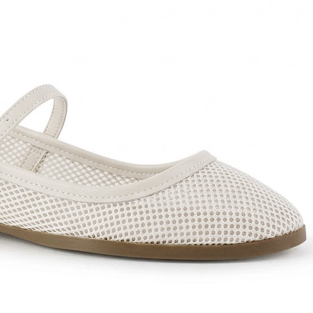 Vista a detalle de modelo perforado en flats tipo balerinas beige para mujer con pulsera ajustable sobre empeine