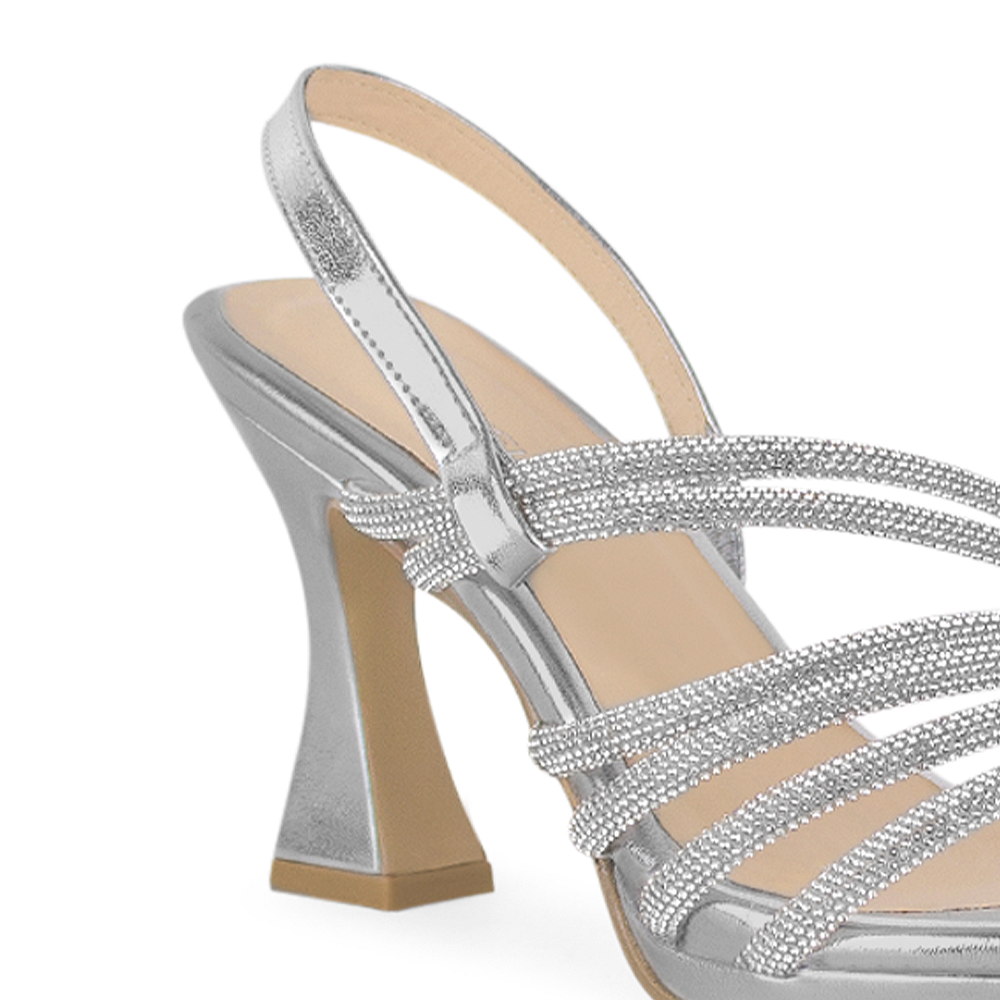 Vista a detalle de zapatilla plata para mujer con tiras de pedrería y correa trasera