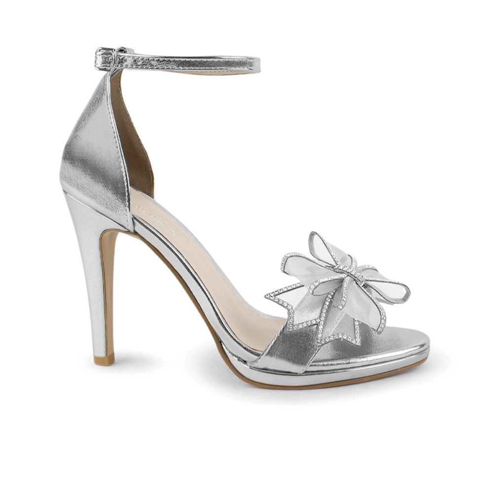 Vista lateral de zapatilla plata para mujer con moño brillante y tacón delgado medio de 10cm 