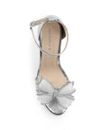 Vista superior de zapatilla plata para mujer con pulsera ajustable y moño con pedrería 