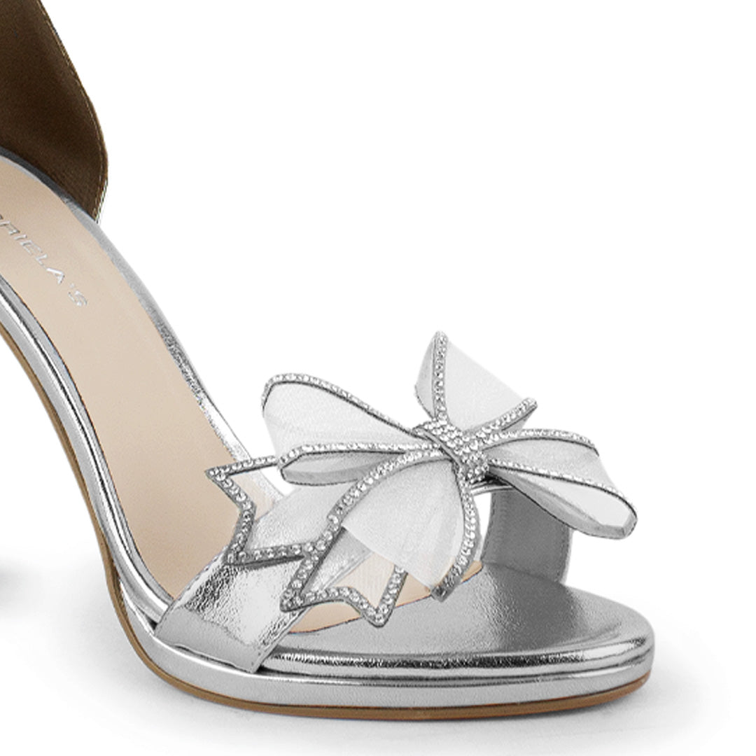 Vista a detalle de zapatilla para mujer con detalle brilloso en moño frontal en color plata
