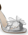 Vista a detalle de zapatilla para mujer con detalle brilloso en moño frontal en color plata