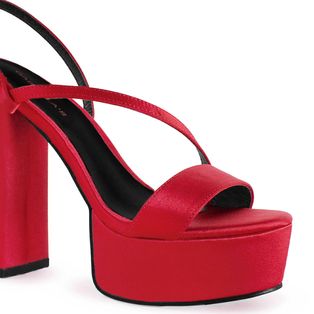 Vista a detalle de plataforma al frente con tiras delgadas cruzadas en zapatilla roja de tacón alto 14cm