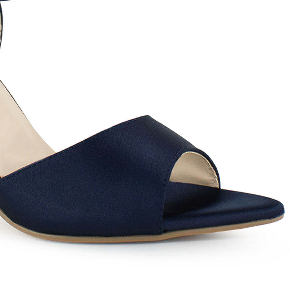 Vista a detalle de punta fina abierta en zapatilla azul para mujer con pulsera y tacón delgado de 10cm