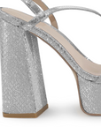 Vista trasera de tacón alto grueso de 14cm en zapatilla plateada para mujer con tiras delgadas cruzadas colgante brillante de diseño descubierto