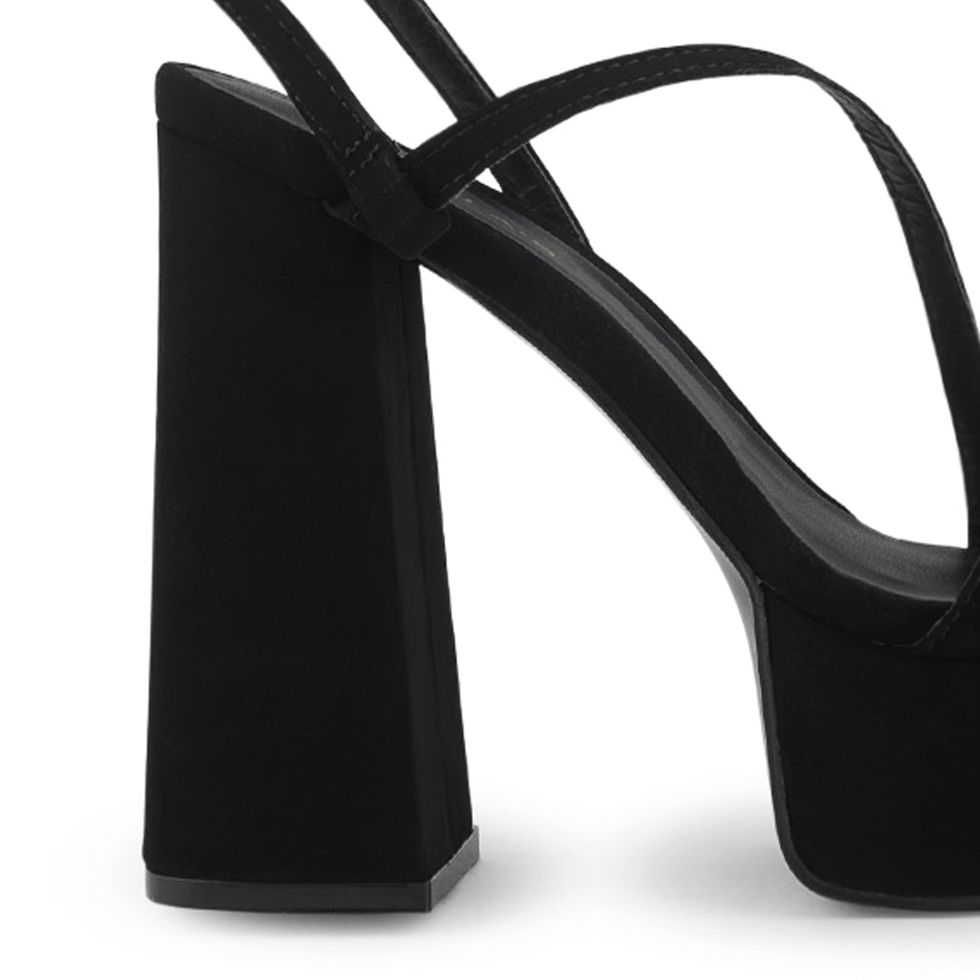 Vista trasera de tacón alto grueso de 14cm en zapatilla negra para mujer con tiras delgadas cruzadas colgante brillante de diseño descubierto