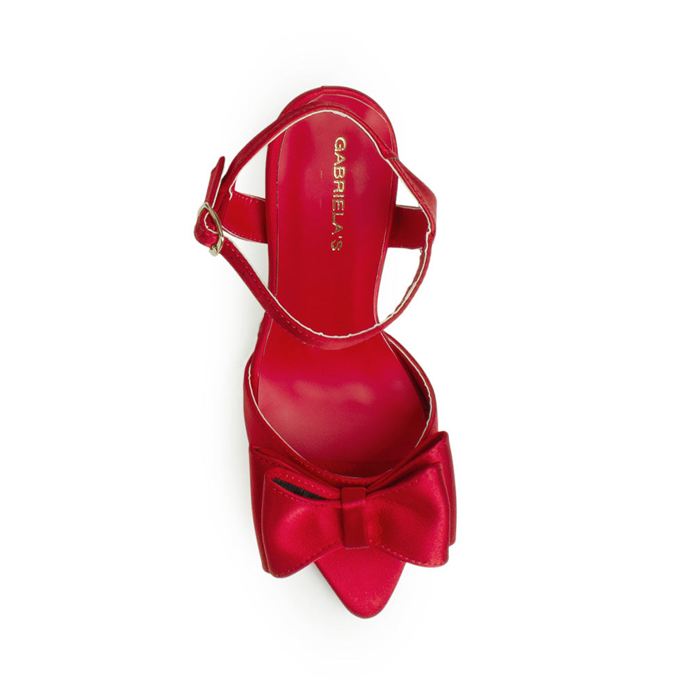 Vista superior de zapatilla roja con moño punta abierta pulsera ajustable y tacón medio 10cm para dama