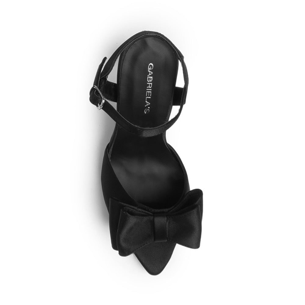 Vista superior de zapatilla negra con moño punta abierta pulsera ajustable y tacón medio 10cm para dama