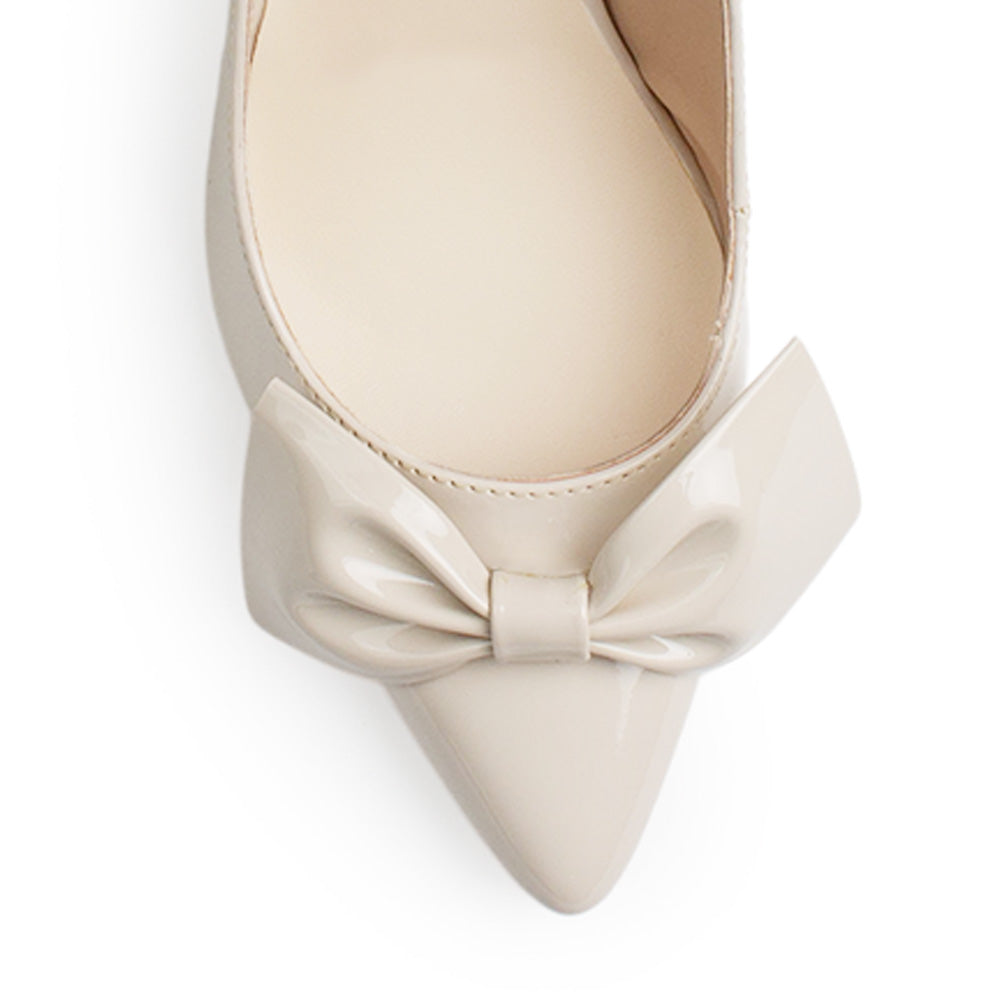 Vista de material charol en zapatilla destalonada tipo stiletto para mujer con moño en punta fina cerrada de tacón delgado de 8cm en color beige 