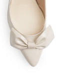 Vista de material charol en zapatilla destalonada tipo stiletto para mujer con moño en punta fina cerrada de tacón delgado de 8cm en color beige 
