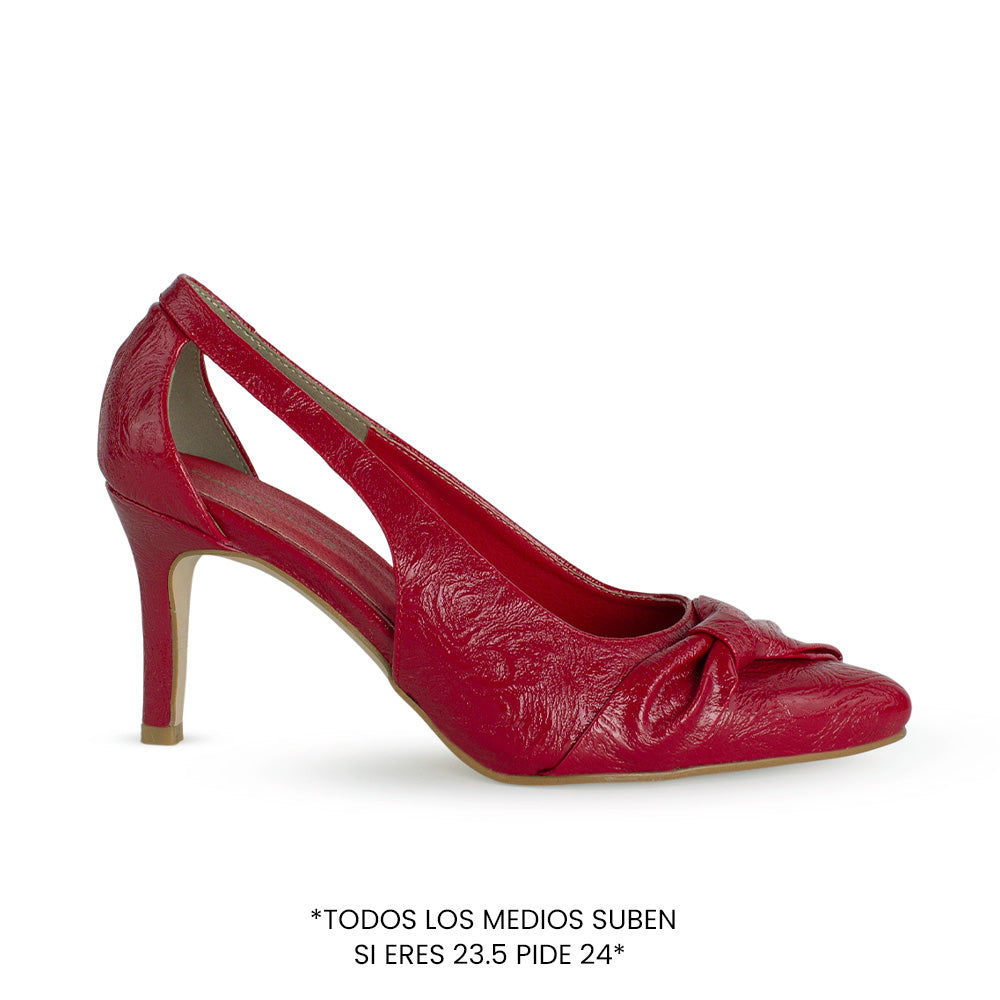 vista lateral de zapatillas rojas puntales para dama con tacón medio 8cm y sutil moño lateral 