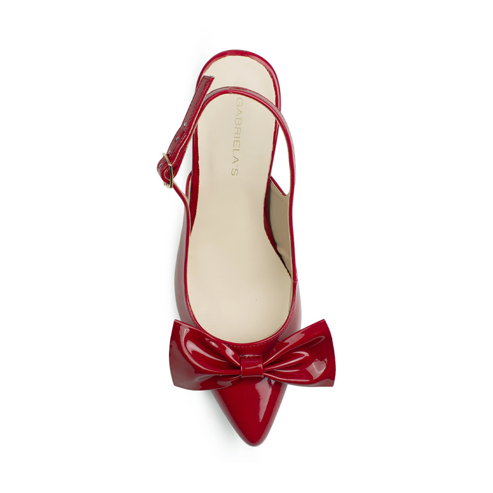 Vista superior de zapatilla roja destalonada tipo stiletto para mujer con punta fina cerrada y moño elegante