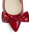 Vista de material charol en zapatilla destalonada tipo stiletto para mujer con moño en punta fina cerrada de tacón delgado de 8cm en color rojo