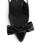 Vista de material charol en zapatilla destalonada tipo stiletto para mujer con moño en punta fina cerrada de tacón delgado de 8cm en color negro