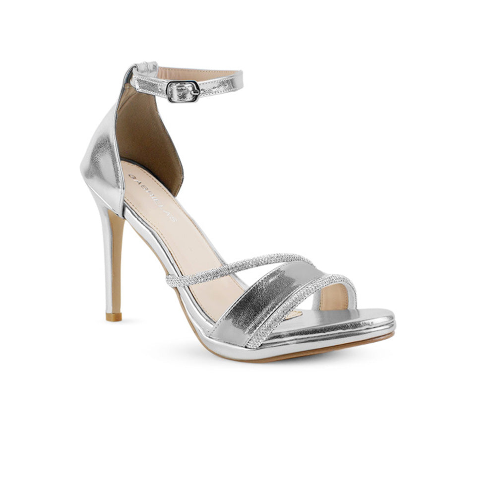 vista diagonal de zapatillas plateadas para dama con pulsera ajustable al tobillo y tiras delgadas de pedrería con tacón medio 10 cm 