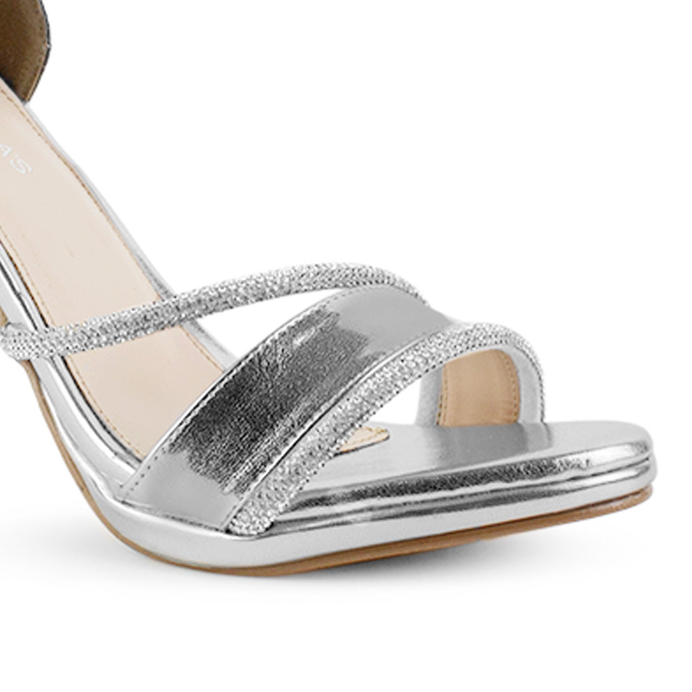 detalle del material sintético en zapatillas plateadas de fiesta para dama con tiras de pedrería y pulsera ajustable al tobillo  