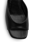 Vista de material sintético en zapatilla negra para mujer con punta abierta cuadrada de meter con tacón bajo de 6cm
