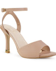 Vista diagonal de zapatilla nude de diseño descubierto para mujer con tacón delgado medio de 10cm y pulsera ajustable al tobillo con hebilla metálica