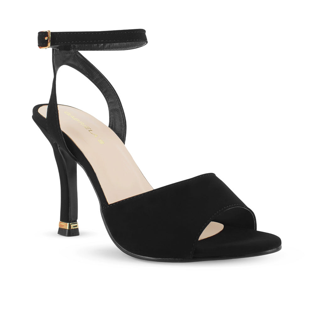 Vista diagonal de zapatilla negra de diseño descubierto para mujer con tacón delgado medio de 10cm y pulsera ajustable al tobillo con hebilla metálica