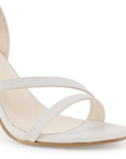 Detalle del material cabra sintético en zapatilla beige para dama con tiras delgadas y tacón medio 10cm