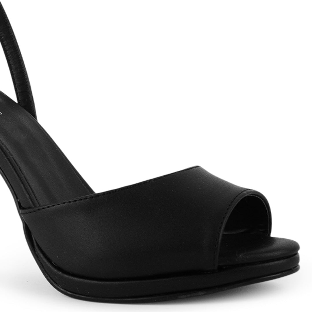 Detalle del material cabra sintético en zapatilla negra con punta abierta, plataforma y tacón alto 11cm para dama