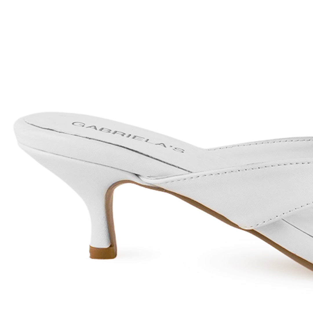 Vista trasera de tacón delgado bajo de 6cm en zapatilla blanca en diseño descubierto para mujer con pata de gallo