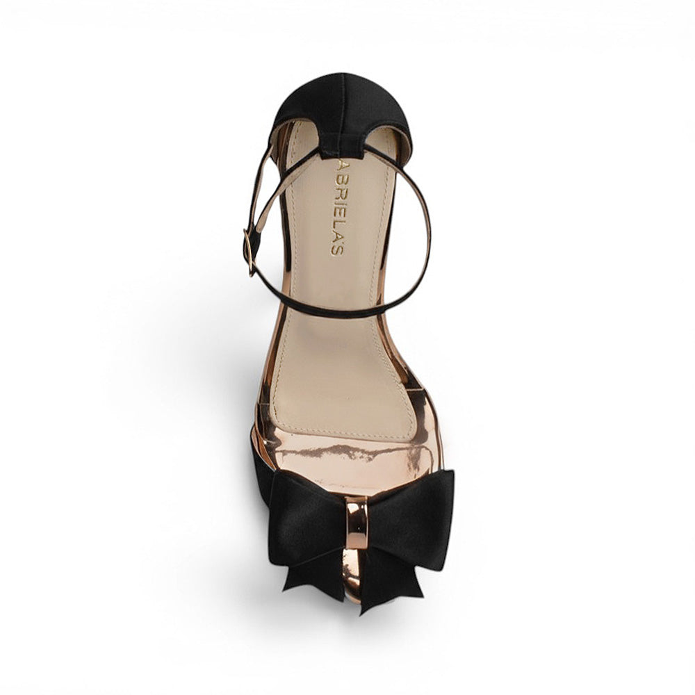 Vista superior de zapatilla negra para mujer con pulsera ajustable al tobillo y moño al frente 