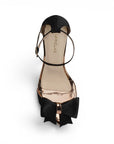Vista superior de zapatilla negra para mujer con pulsera ajustable al tobillo y moño al frente 