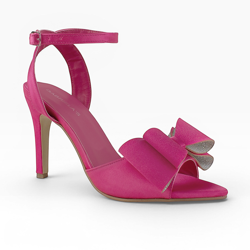 Vista diagonal de zapatilla rosa para mujer de diseño descubierto con moño y tacón delgado de 10cm