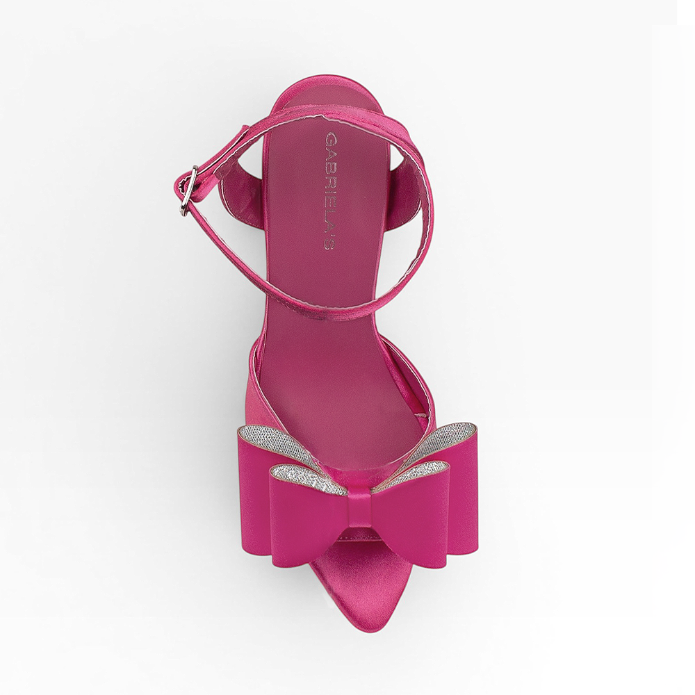 Vista superior de zapatilla rosa de diseño descubierto para mujer con moño elegante punta fina y correa ajustable al tobillo 