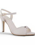 Vista diagonal de zapatillas beige para mujer con pulsera ajustable al tobillo punta fina abierta y tacón delgado de 10cm
