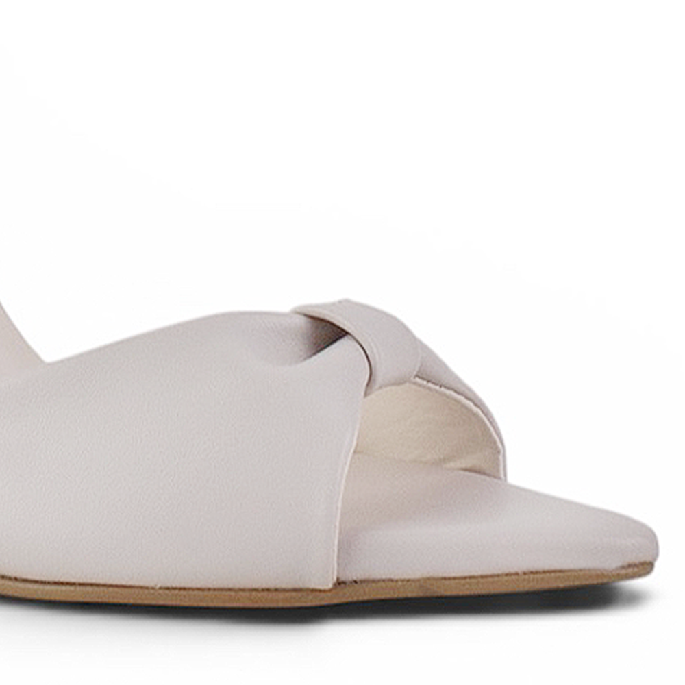 Vista a detalle de punta fina abierta en zapatilla beige para mujer con pulsera ajustable y tacón delgado medio de 10cm de diseño descubierto