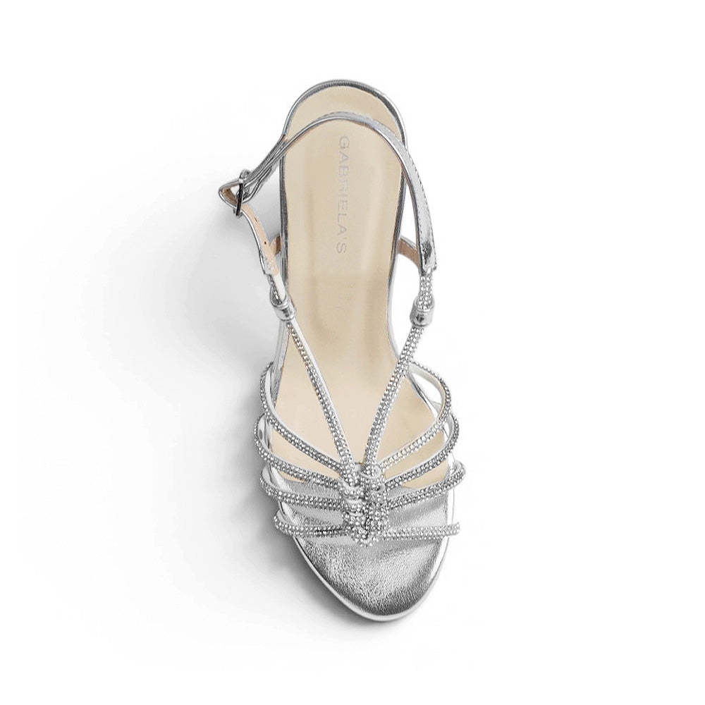 Vista superior de zapatilla de diseño descubierto nude para mujer con tiras de pedrería cruzadas en color plateado