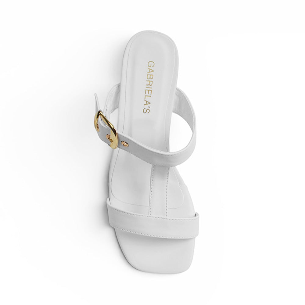 vista superior de zapatillas blancas con hebilla dorada en tiras gruesas para dama 