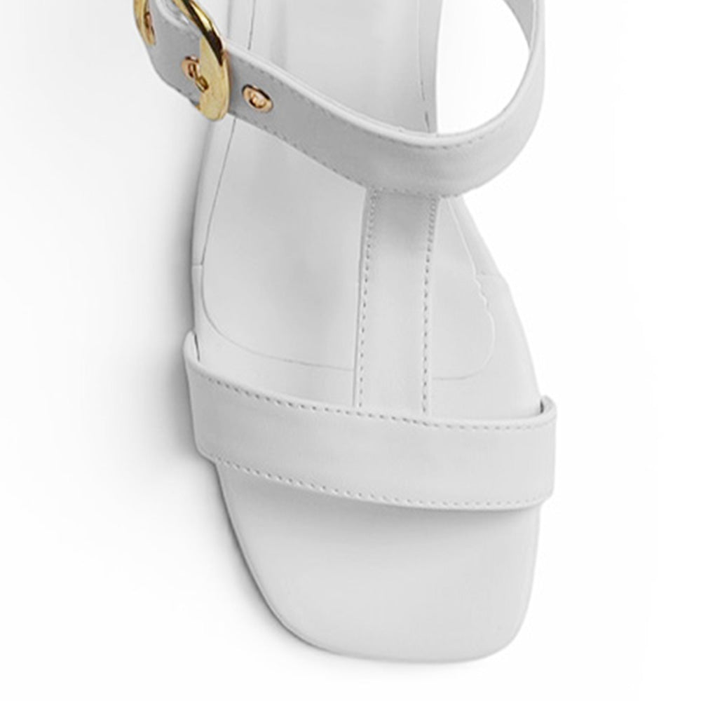 vista del detalle en tiras gruesas con hebilla dorada en zapatillas blancas de dama con tacón bajo 5cm