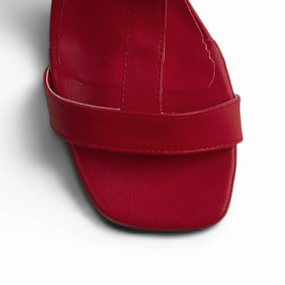 vista del detalle en tiras gruesas con hebilla dorada en zapatillas rojas de dama con tacón bajo 5cm