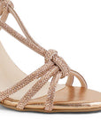 detalle del material sintético en las zapatillas oro rosado para dama con tiras cruzadas de brillos  