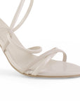detalle del material charol en zapatillas beige para dama con tiras cruzadas y tacón medio 10 cm 
