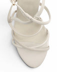 vista del detalle en tiras cruzadas de las zapatillas beige de charol 