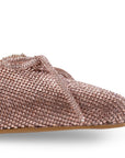 Detalle del material cabra sintético en la zapatilla oro rosa de pedrería con punta fina y moño para dama  