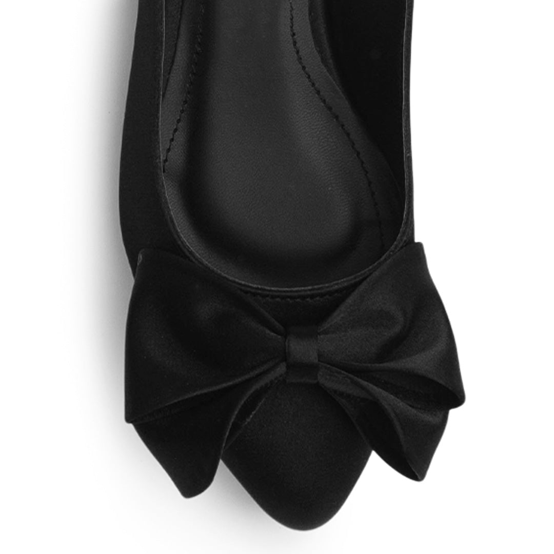 Vista de material shantung en flats negros para mujer con moño en punta fina destalonado con pulsera ajustable trasera