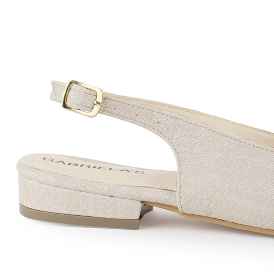 Vista trasera de flat beige para mujer con diseño destalonado de piso y pulsera con hebilla ajustable