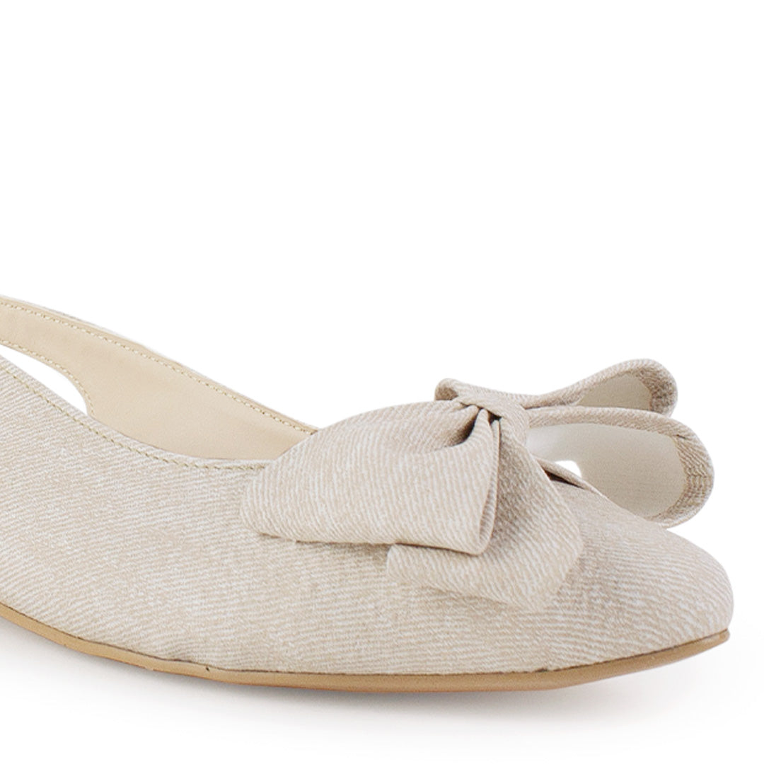 Vista a detalle de punta fina con moño en flats beige para mujer con diseño destalonado y correa ajustable 