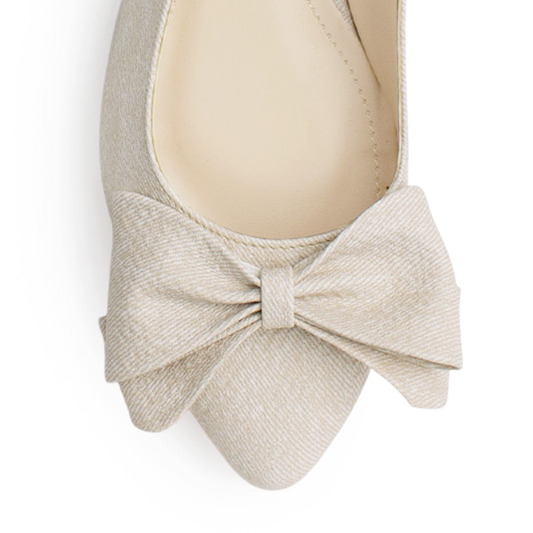 Vista de material sintético en flats beige para mujer con moño en punta fina destalonado con pulsera ajustable trasera