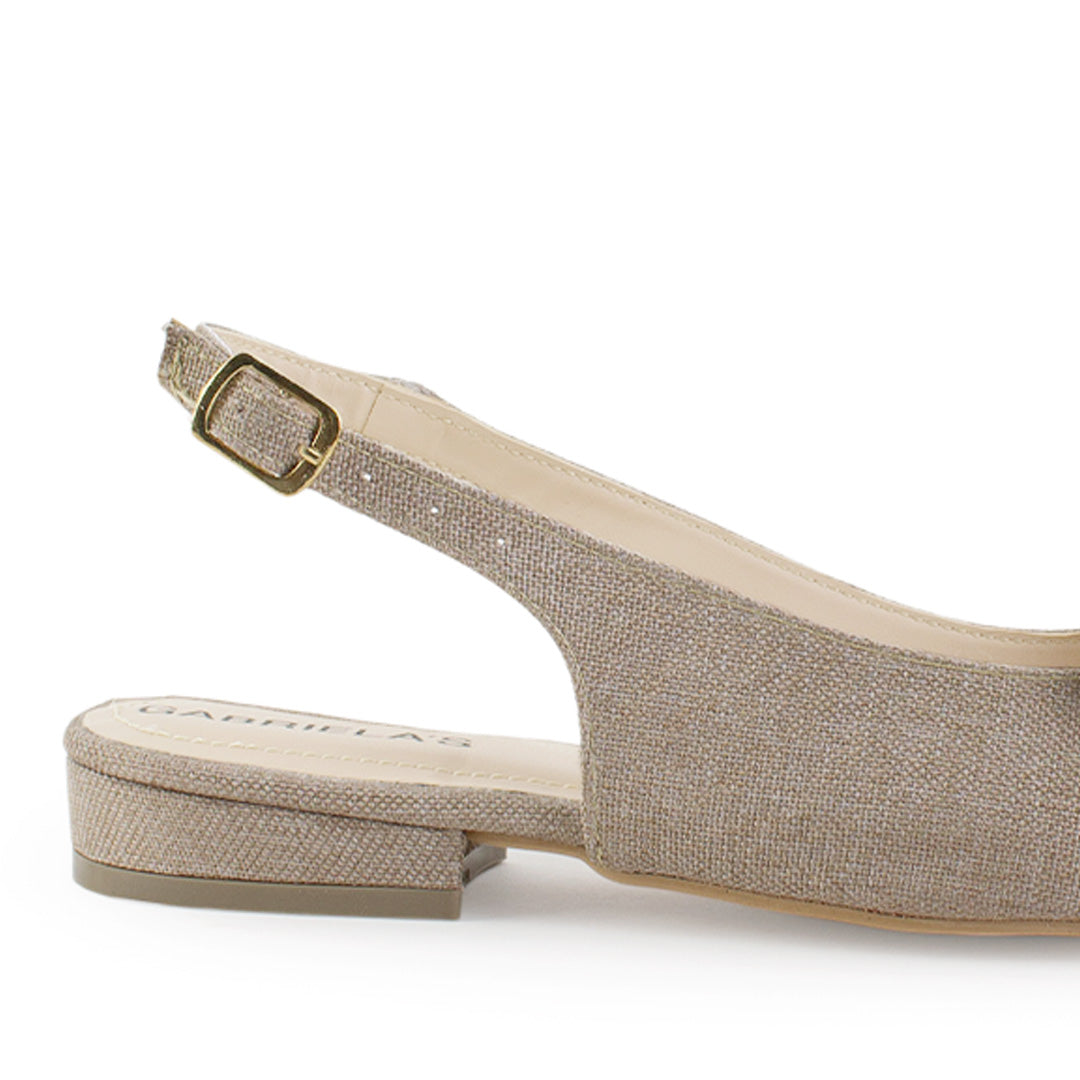 Vista trasera de flat beige para mujer con diseño destalonado de piso y pulsera con hebilla ajustable