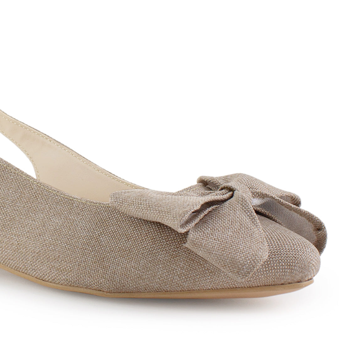 Vista a detalle de punta fina con moño en flats beige para mujer con diseño destalonado y correa ajustable 
