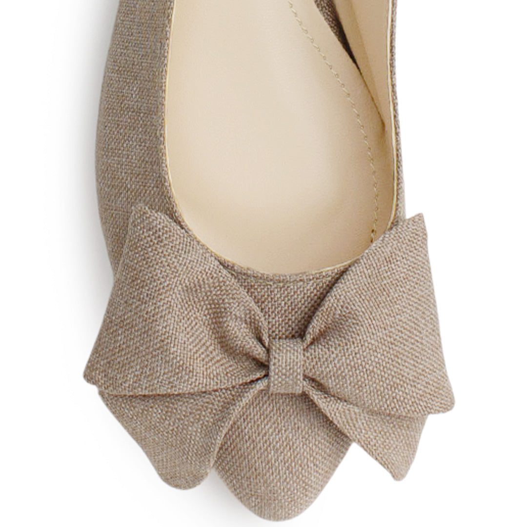 Vista de material sintético en flats beige para mujer con moño en punta fina destalonado con pulsera ajustable trasera