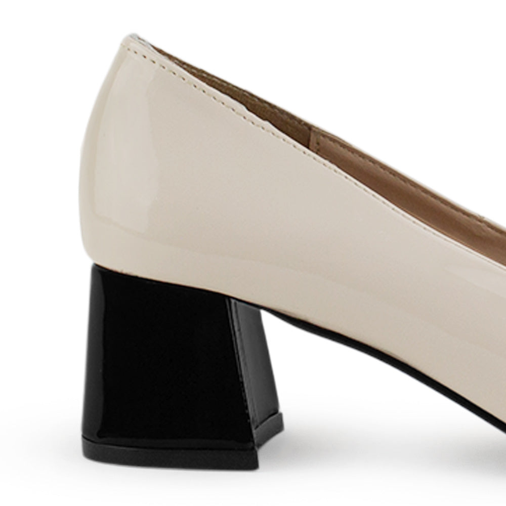 Vista trasera del tacón bajo 5 cm en zapatilla beige de charol para dama con punta fina y detalles negros 