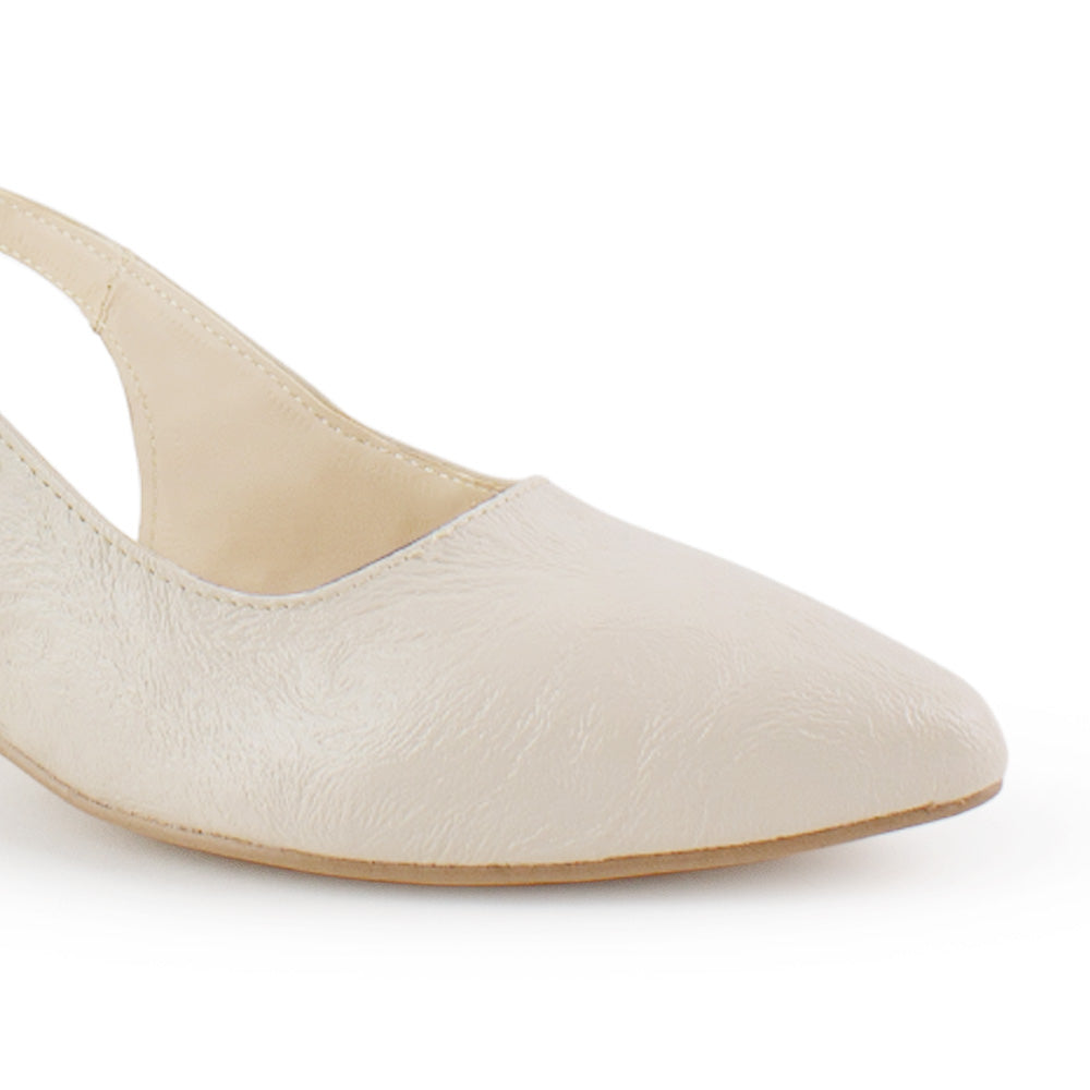 Vista a detalle de punta fina cerrada en zapatilla beige para mujer con correa ajustable y tacón bajo de 5cm